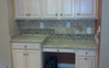 Kitchen desk and cabinets with new granite countertop and back-splash tiles designed to accentuate different countertop heights.